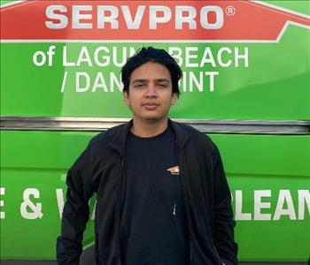 male employee standing in front of a green wall