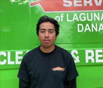 male employee standing in front of a green wall