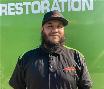 male employee standing in front of a green wall