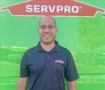 male employee standing in front of a green wall