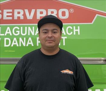 male employee standing in front of a green wall