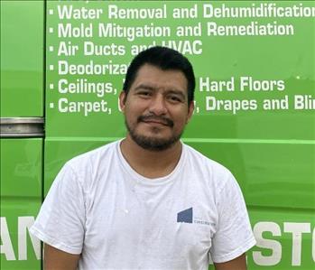 male employee standing in front of a green wall