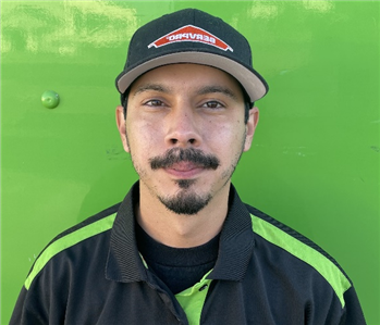 male employee standing in front of a green wall