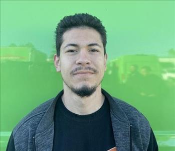 male employee standing in front of a green wall