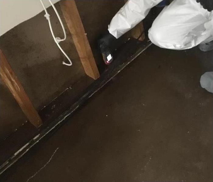 worker with moisture meter on dry wall